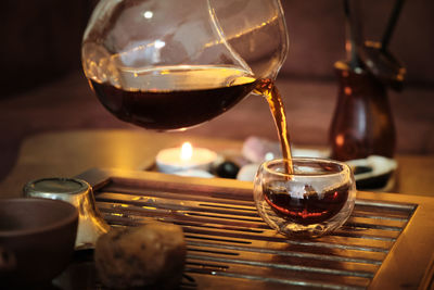 Brewing puerh tea. traditional chinese tea ceremony. tea pouring from teapot to glass cup on a tray