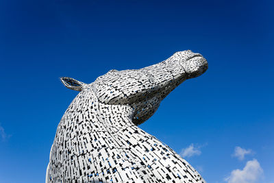 Low angle view of statue against blue sky