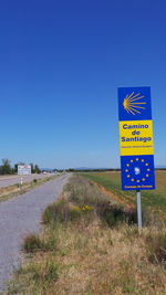 Road sign against clear blue sky