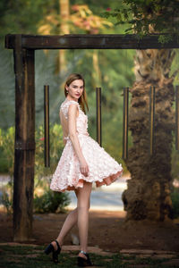 Portrait of smiling young woman standing by bells