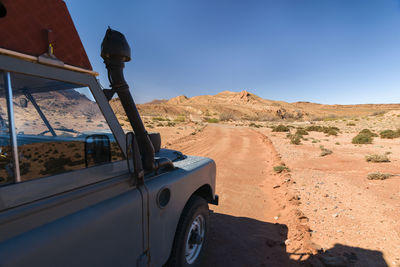 Car on desert against sky
