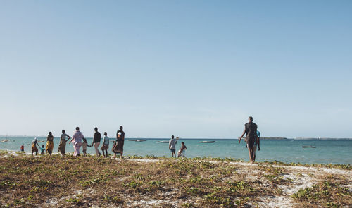 People at beach against sky