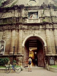 Low angle view of woman walking in front of building