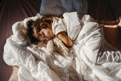 Sweet little girl sleeping in motor home with stuffed rabbit toy