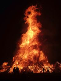 Silhouette bonfire against sky at night