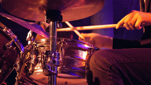 Midsection of man playing drum during music concert