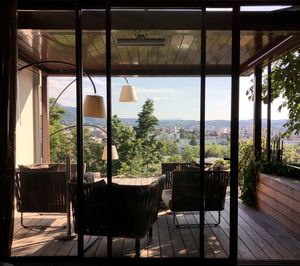 Empty chairs and tables by window