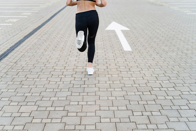 Low section of woman running on street