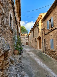 Narrow alley amidst houses in town. old town pollença, mallorca, spain.