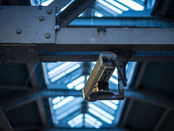 Low angle view of old security camera in train station