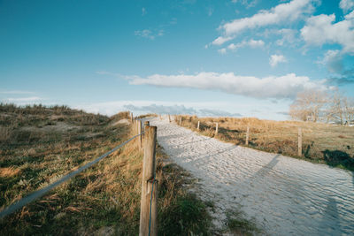 Wooden fence on field against sky