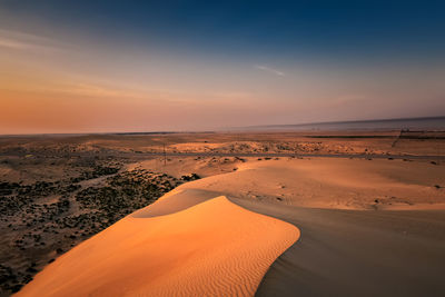 Scenic view of desert against sky during sunset