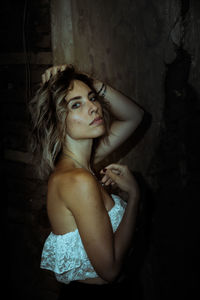 Portrait of young woman against wall