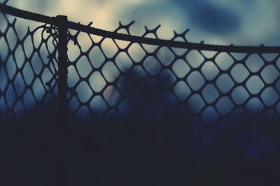 Low angle view of silhouette fence against sky during sunset