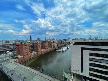 High angle view of river amidst buildings in city against sky