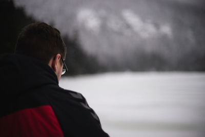 Rear view of man outdoors during winter