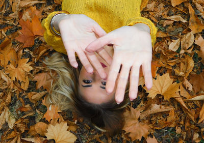 High angle view of woman lying on dry leaves