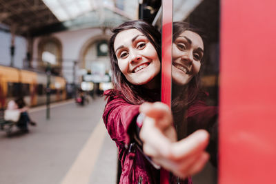 Portrait of smiling woman standing in subway train