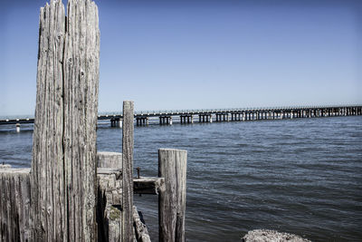 Wooden pier on sea against clear sky