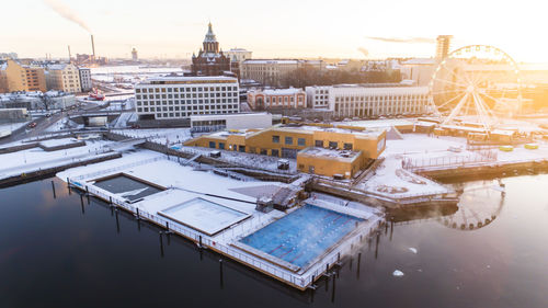 High angle view of buildings by lake against sky