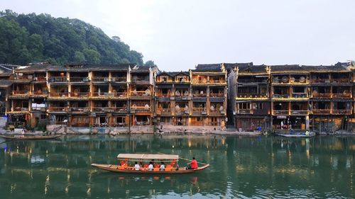 Boats in river against sky