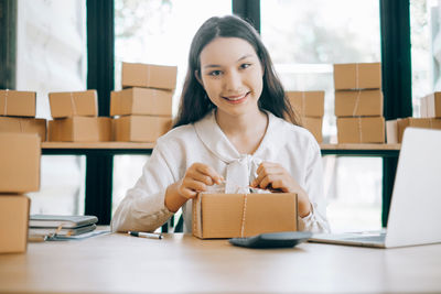 Portrait of a smiling young woman using phone