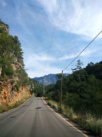 Road amidst trees against sky