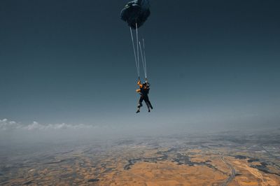 Person paragliding against sky