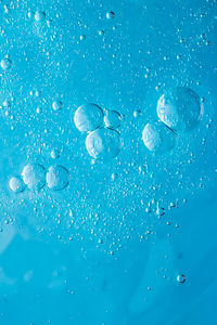 Close-up of water drops on blue glass