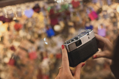 Cropped hands of woman holding camera