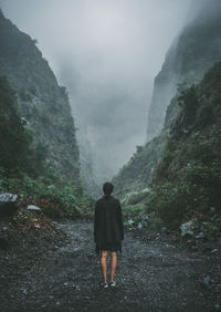 Rear view of man walking on mountain road