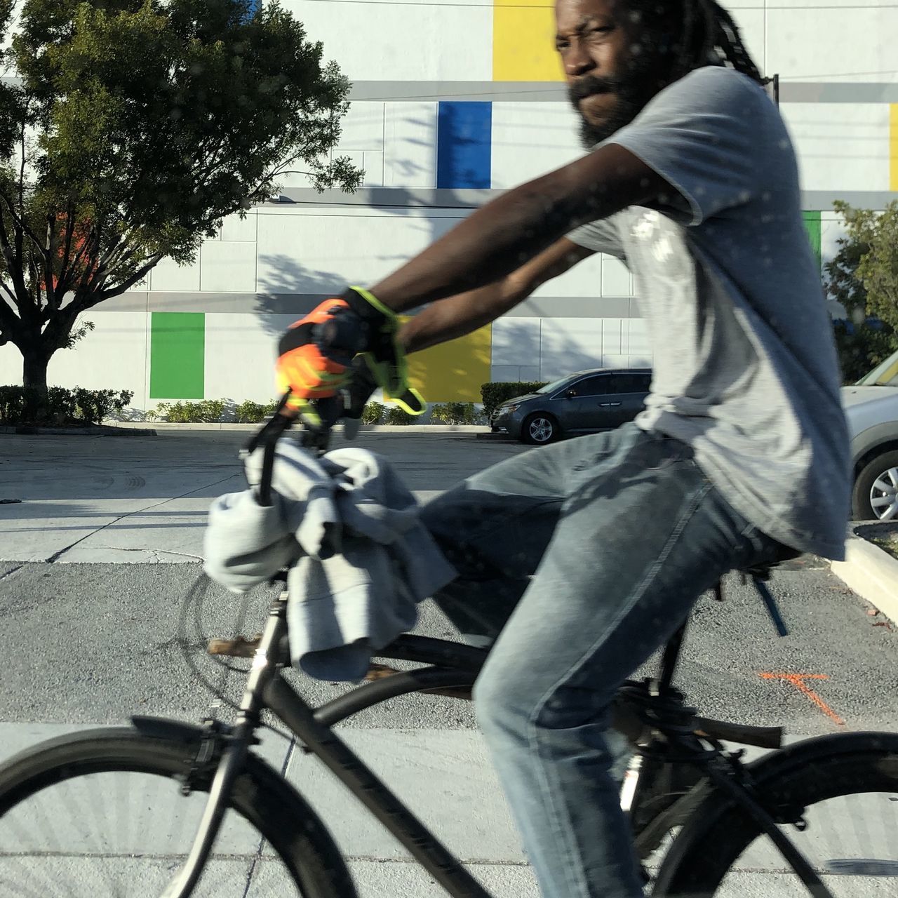 MAN RIDING BICYCLE ON ROAD IN CITY