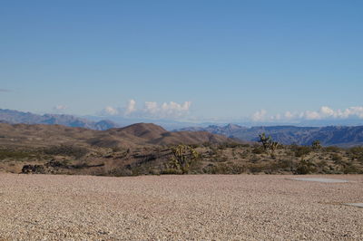 Scenic view of mountains against blue sky