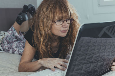 Adult woman with laptop in the room or bedroom