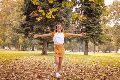 Portrait of woman standing on field during autumn