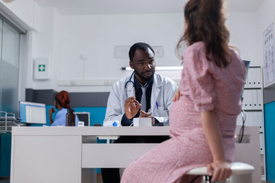 Side view of female friends working at clinic