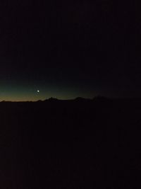 Silhouette landscape against clear sky at night