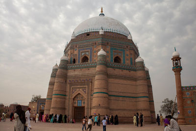 Group of people in front of historical tomb of  shahrukne alam multan against cloudy sky