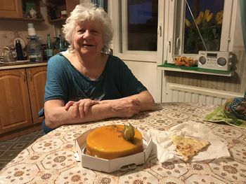 Woman sitting on table at home