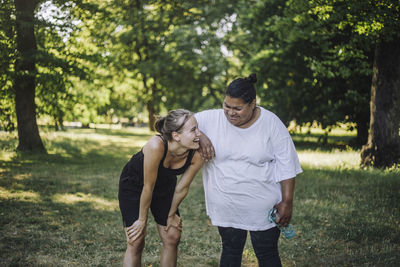 Happy multiracial female friends laughing together at park