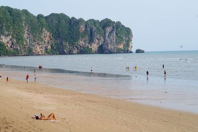 People at beach against sky