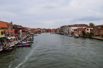 View of boats in sea against cloudy sky