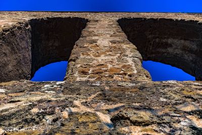 Low angle view of rock formation against clear blue sky