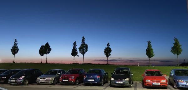 Cars on road against clear blue sky