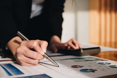 Midsection of woman working on table