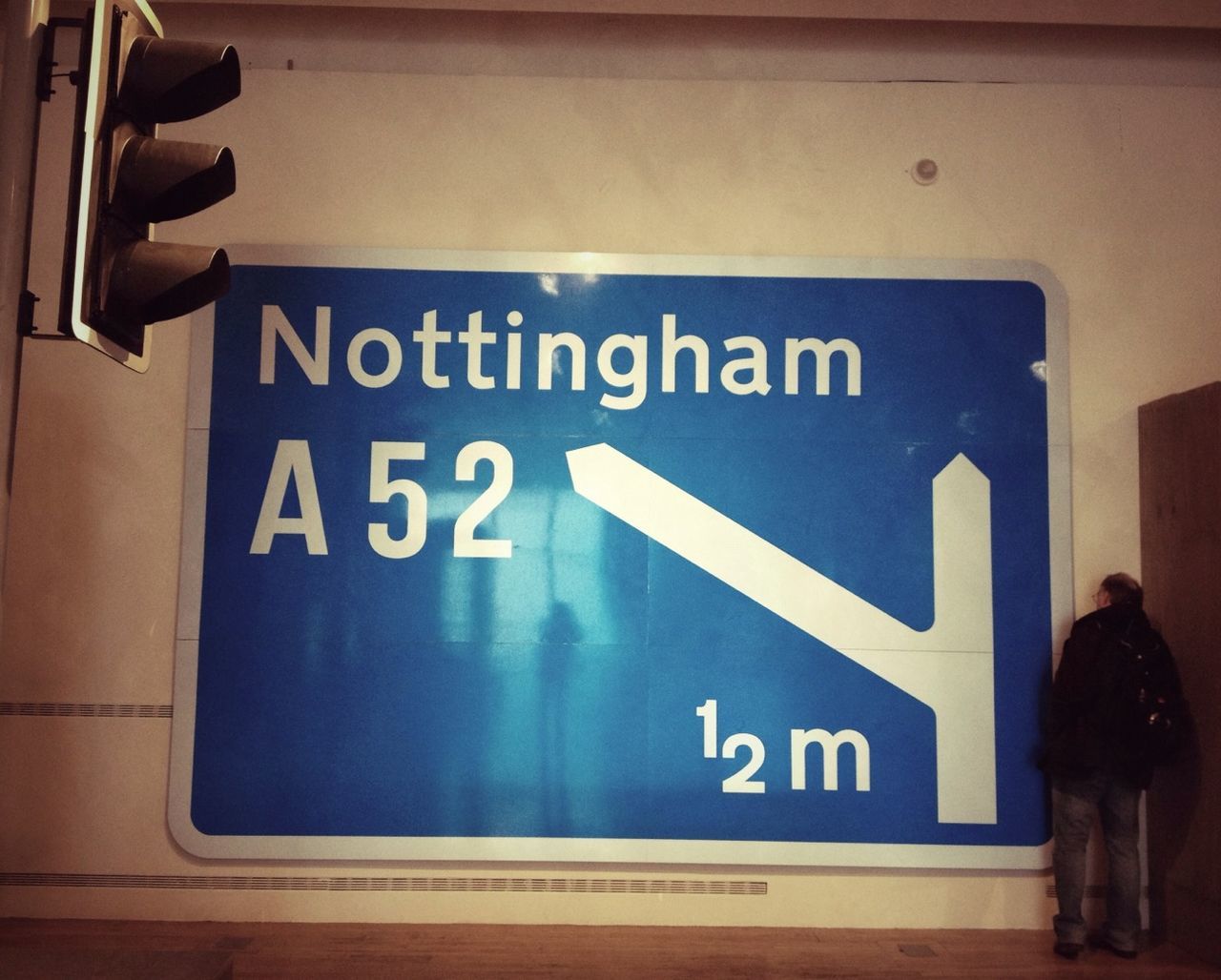 text, communication, western script, information sign, guidance, sign, information, non-western script, capital letter, arrow symbol, road sign, directional sign, direction, transportation, low angle view, warning sign, blue, indoors, number, built structure