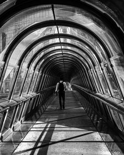 Rear view of man walking on bridge