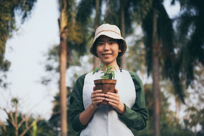 Portrait of smiling man standing against plants