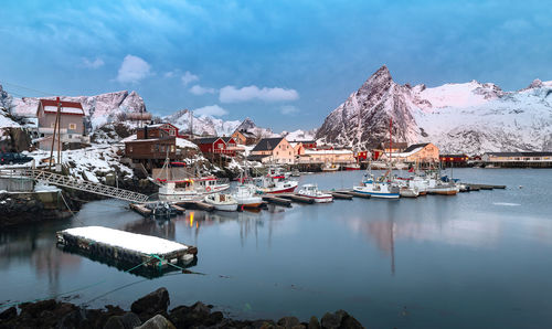 Sailboats moored in lake against sky during winter