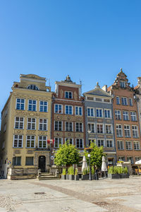 Low angle view of buildings against clear blue sky